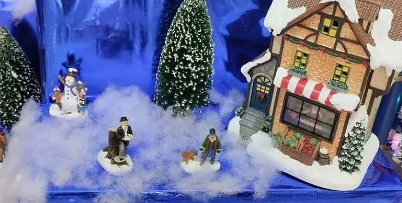 Aldea navideña en miniatura con casitas, pinos y nieve